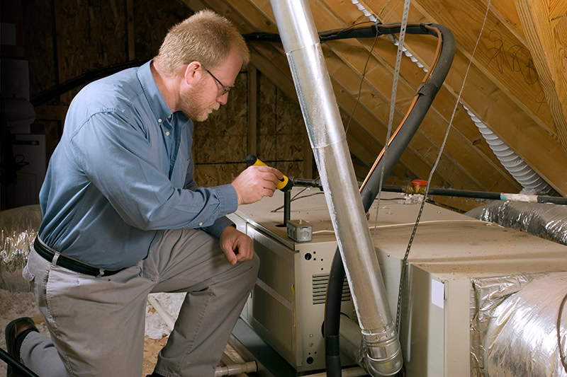 Furnace Maintenance and Winter Energy Saving Tips. Photo of a technician installing a heating system in a home.